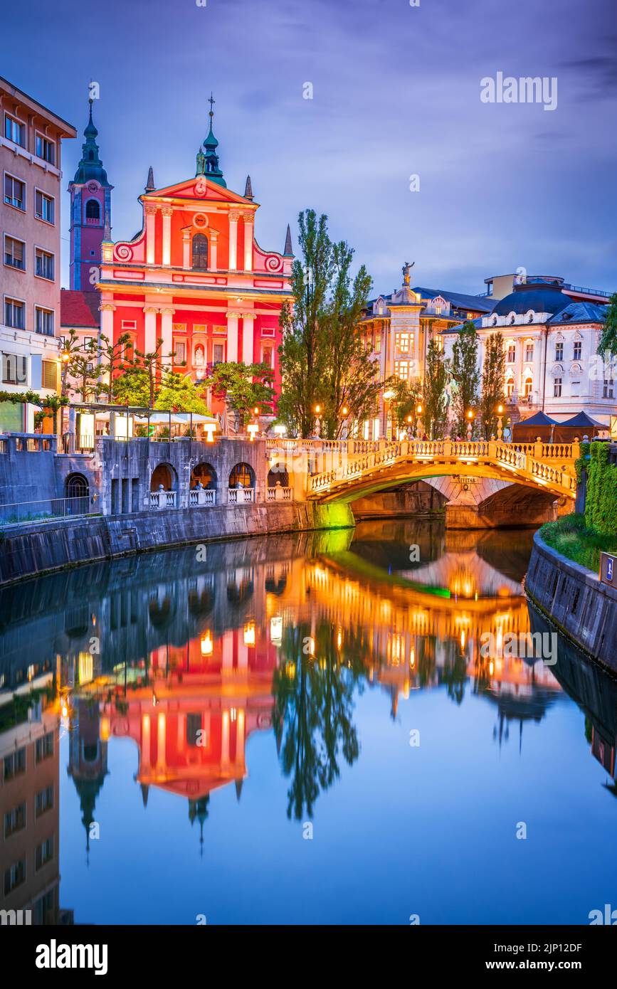 Ljubljana, Slovénie. Pont triple, réflexion sur l'eau de Tromostovje sur la rivière Ljubljana, toile de fond slovène. Banque D'Images