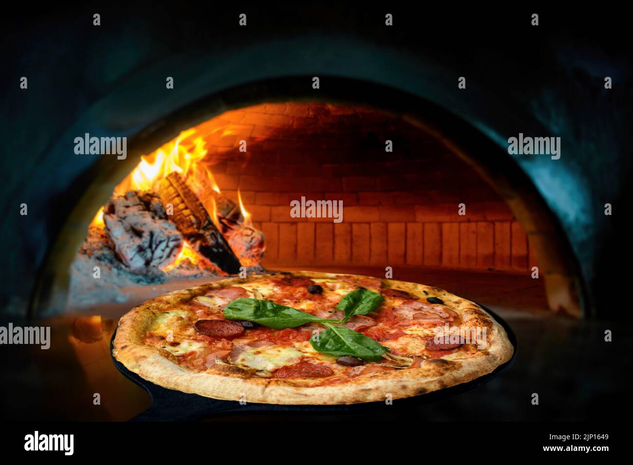 Fermez une délicieuse pizza italienne dans une pelle en mettant dans un four à bois Banque D'Images Fermez une délicieuse pizza italienne dans une pelle en mettant dans un four à bois Banque D'Images