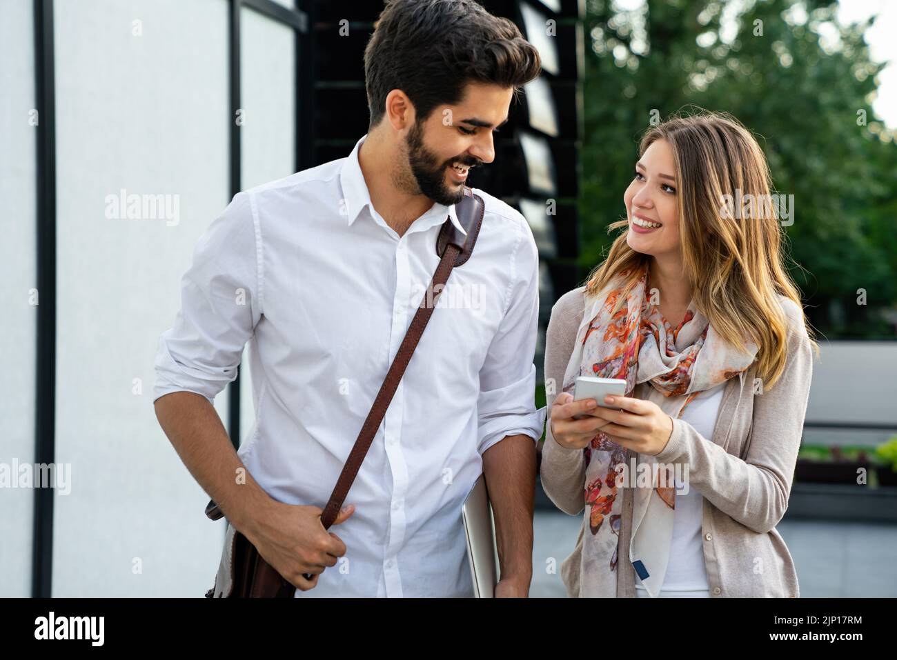 Des gens d'affaires heureux à l'extérieur avec des appareils numériques. Technologie d'entreprise smartphone, concept de tablette Banque D'Images