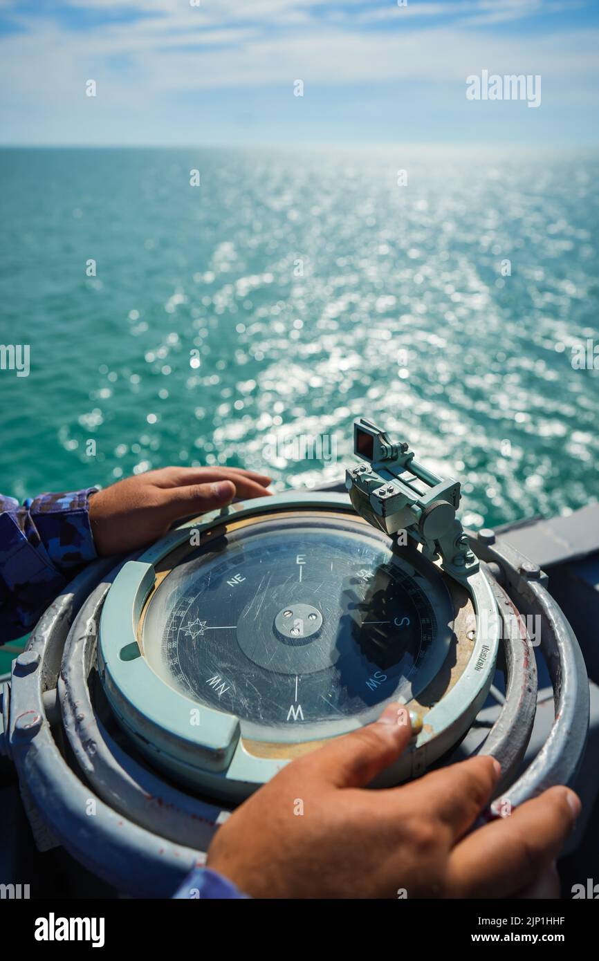 Le personnel militaire lit la boussole sur un navire militaire naviguant sur la mer. Banque D'Images