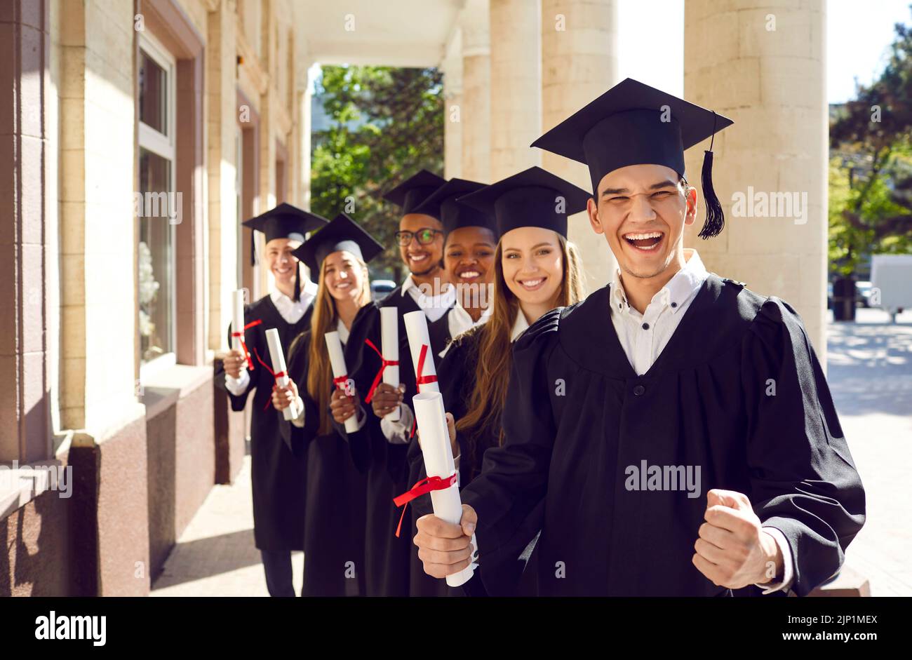 Les heureux diplômés enthousiastes de l'université se réjouissent de la réussite de leurs études. Banque D'Images