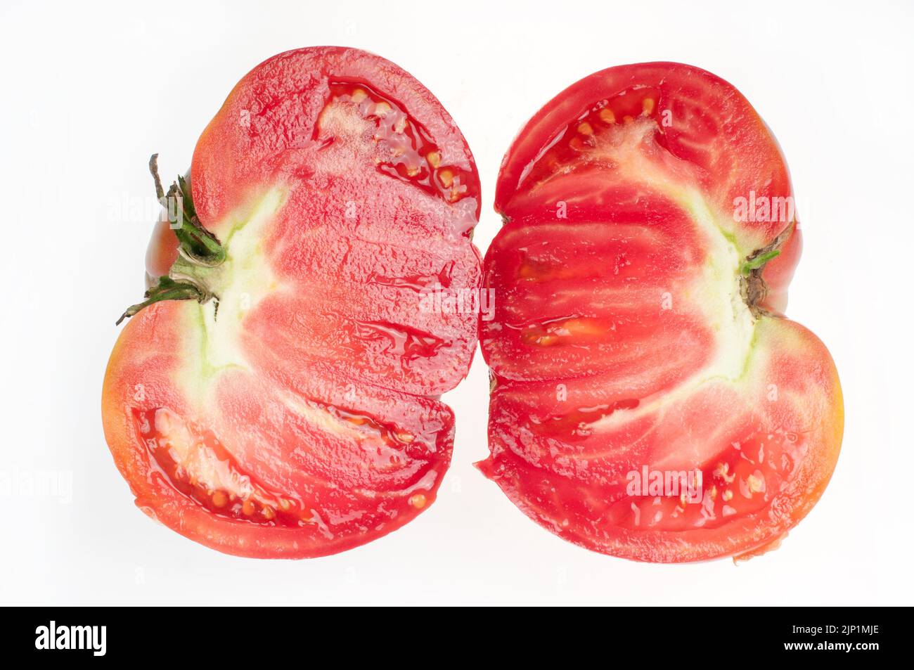 Une grande tomate mûre rouge coupée en deux Banque D'Images