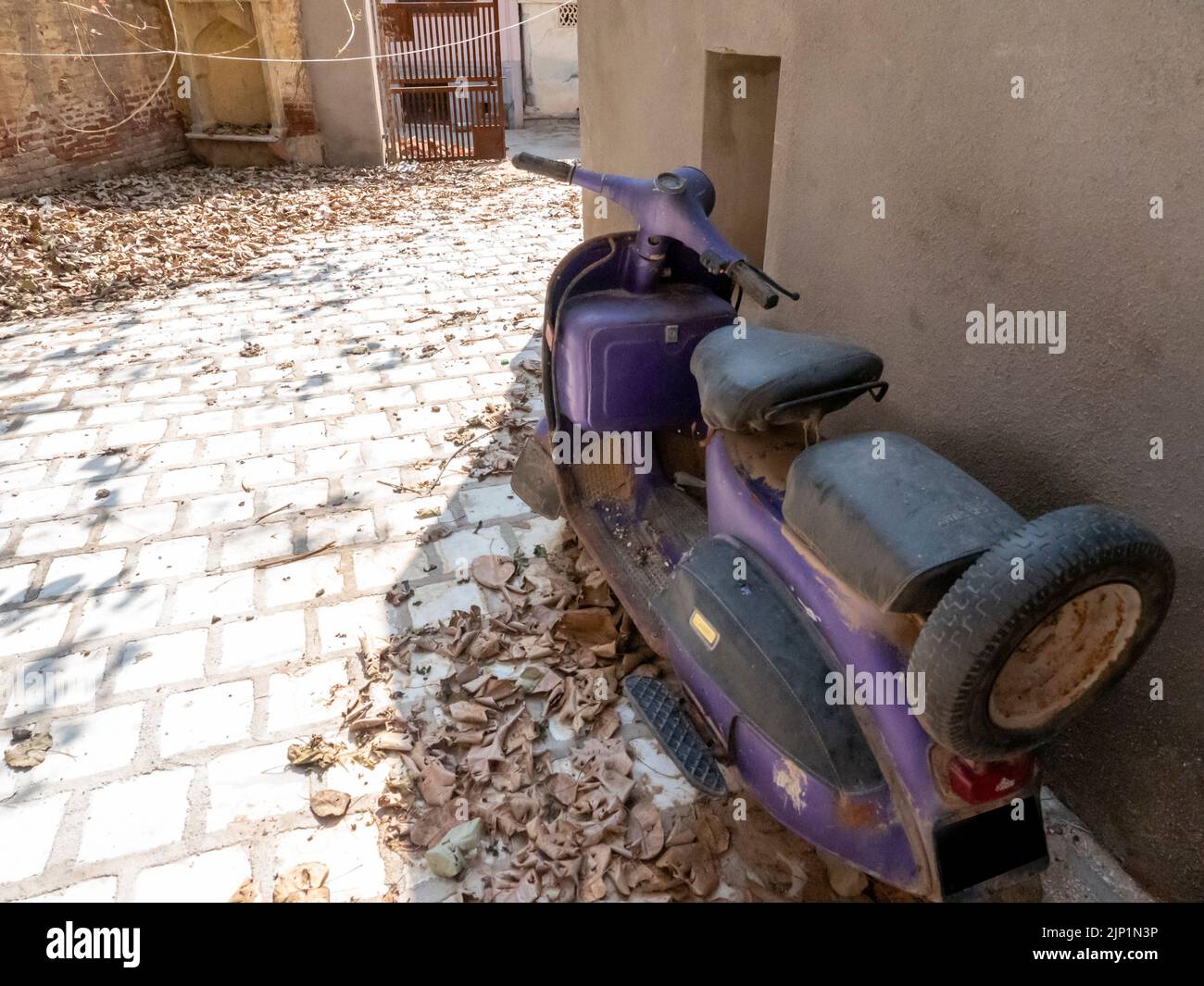 Vieux scooter en Inde, placé dans la maison de village de la vieille ville. Banque D'Images