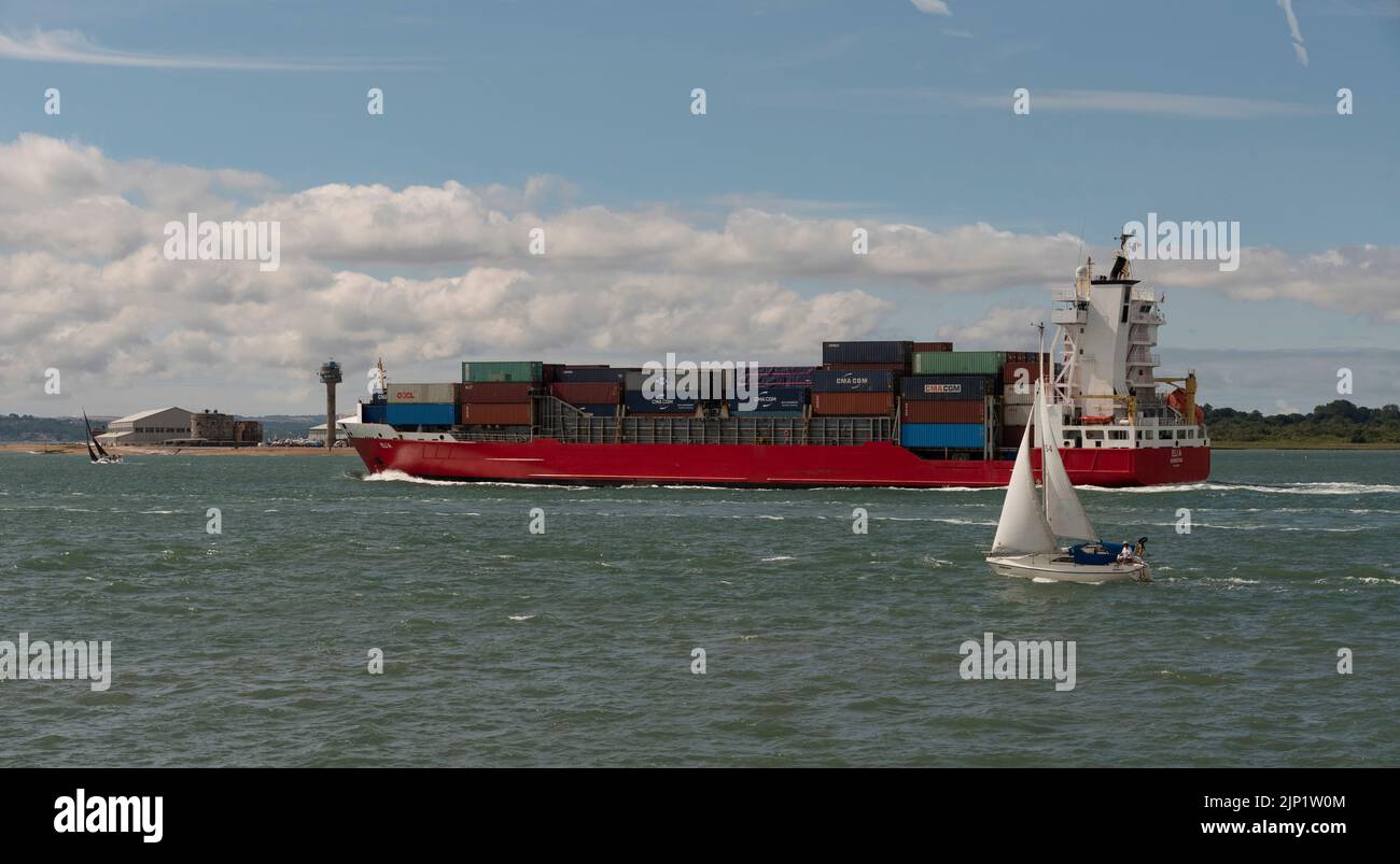 CalShot, Southampton Water , Angleterre, Royaume-Uni. 2022. Navire à conteneurs en cours et passant Calshot sur Southampton Water en passant par un voilier Banque D'Images