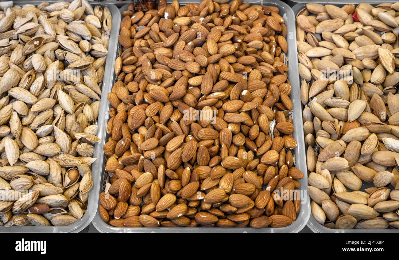 Amandes pelées et non pelées, vente de noix sur le marché. Aliments secs, amandes de variété en magasin pour fond de texture. Concept de saine alimentation, produit brut, b Banque D'Images