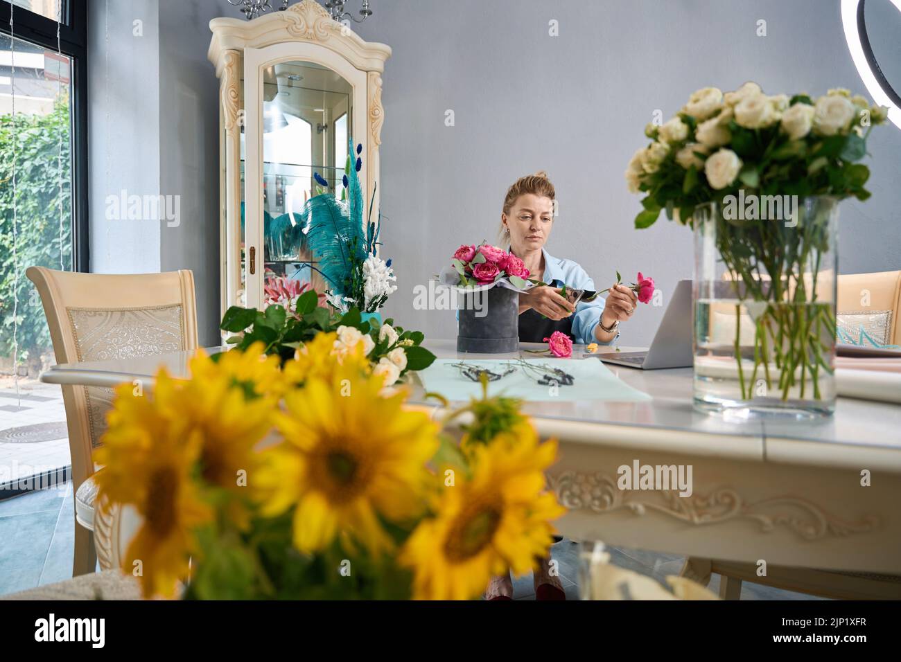 Le fleuriste montre comment créer un bouquet de fleurs dans une boîte. Classe principale en ligne Banque D'Images