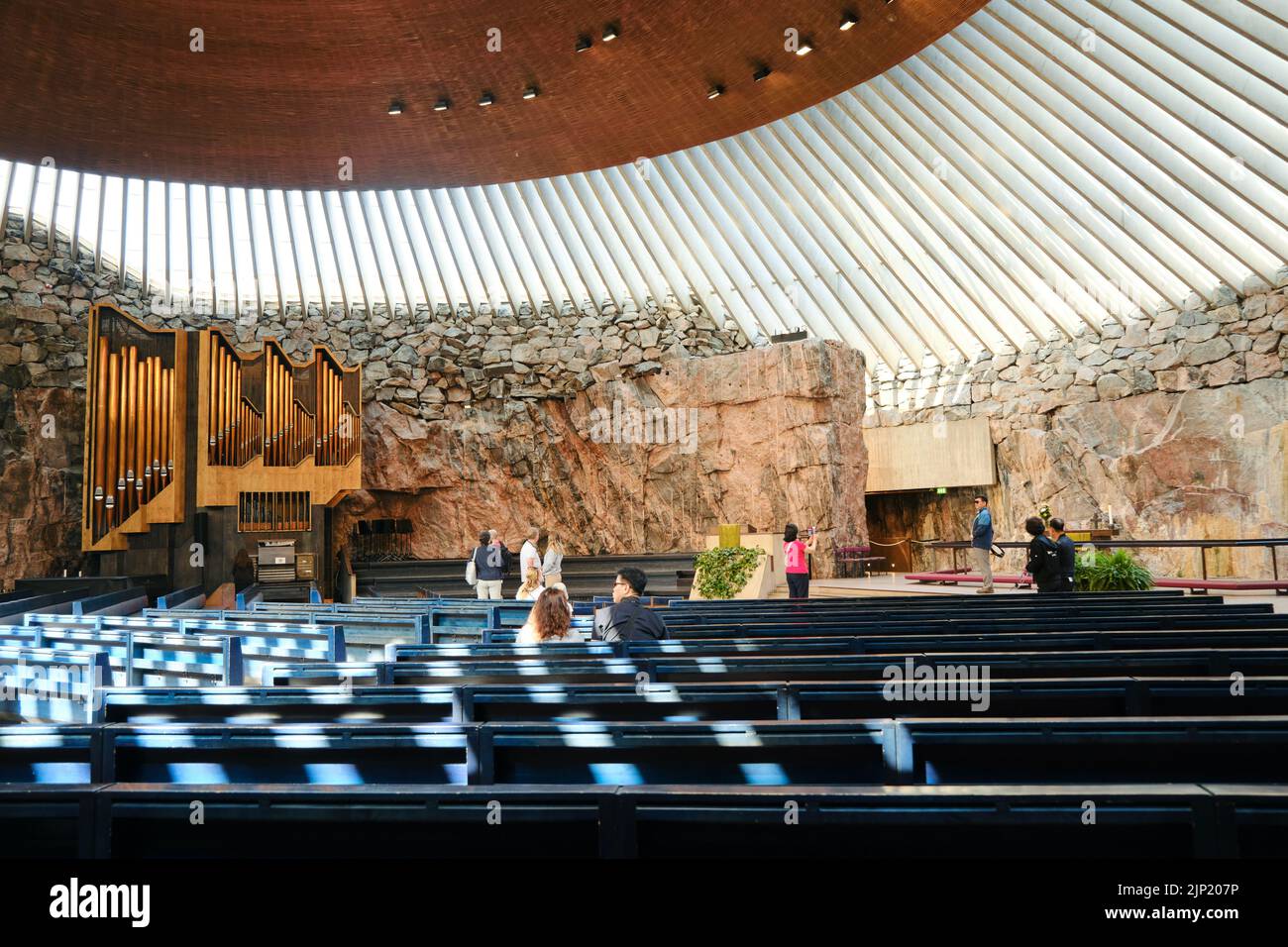 Intérieur de la célèbre église Temppeliaukio construite directement dans le rocher solide avec des touristes à pied à Helsinki, en Finlande Banque D'Images