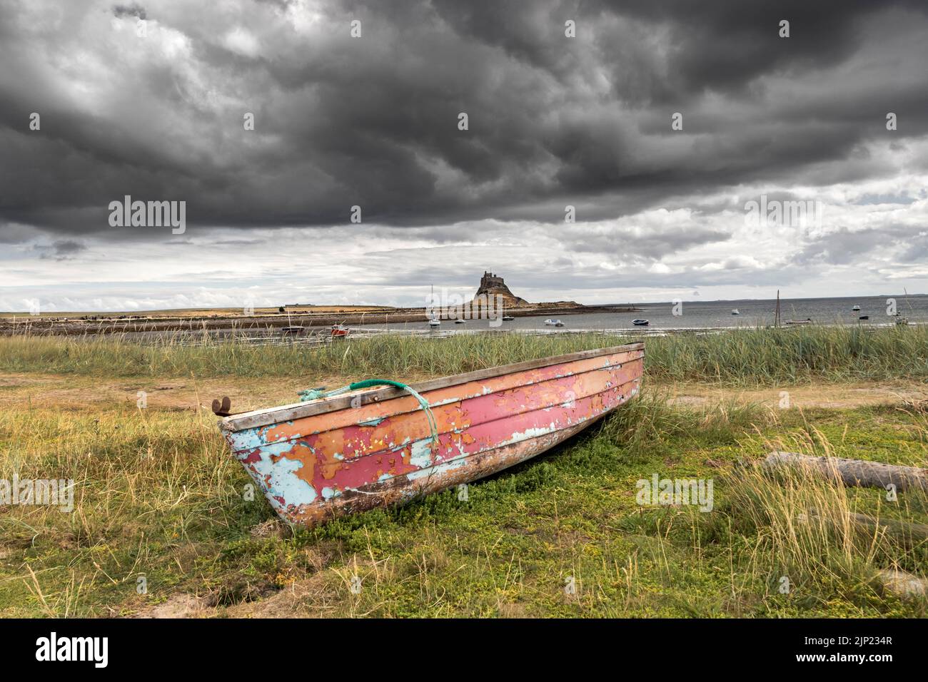 Vieux bateau de pêche avec le château de Lindisfarne en arrière-plan, Lindisfarne (île Sainte), Northumberland, Angleterre, Royaume-Uni Banque D'Images