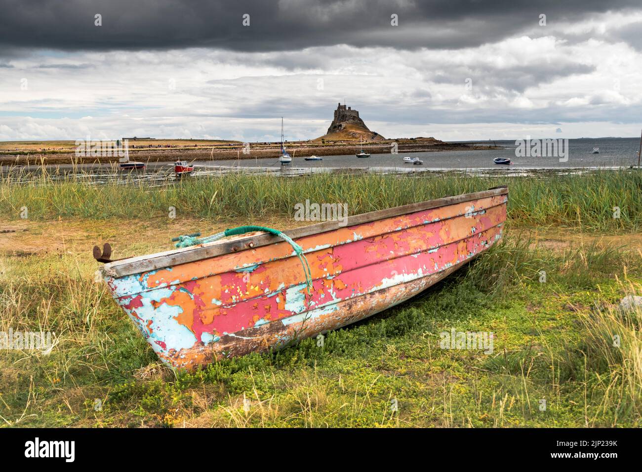 Vieux bateau de pêche avec le château de Lindisfarne en arrière-plan, Lindisfarne (île Sainte), Northumberland, Angleterre, Royaume-Uni Banque D'Images