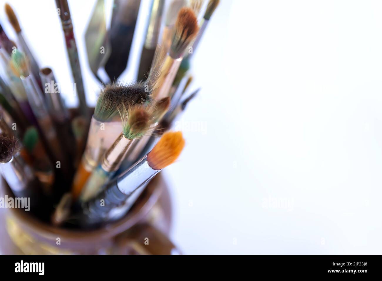 Lieu de travail de l'artiste. Brosses artistiques de différentes tailles et de qualité dans un pot en céramique. Banque D'Images