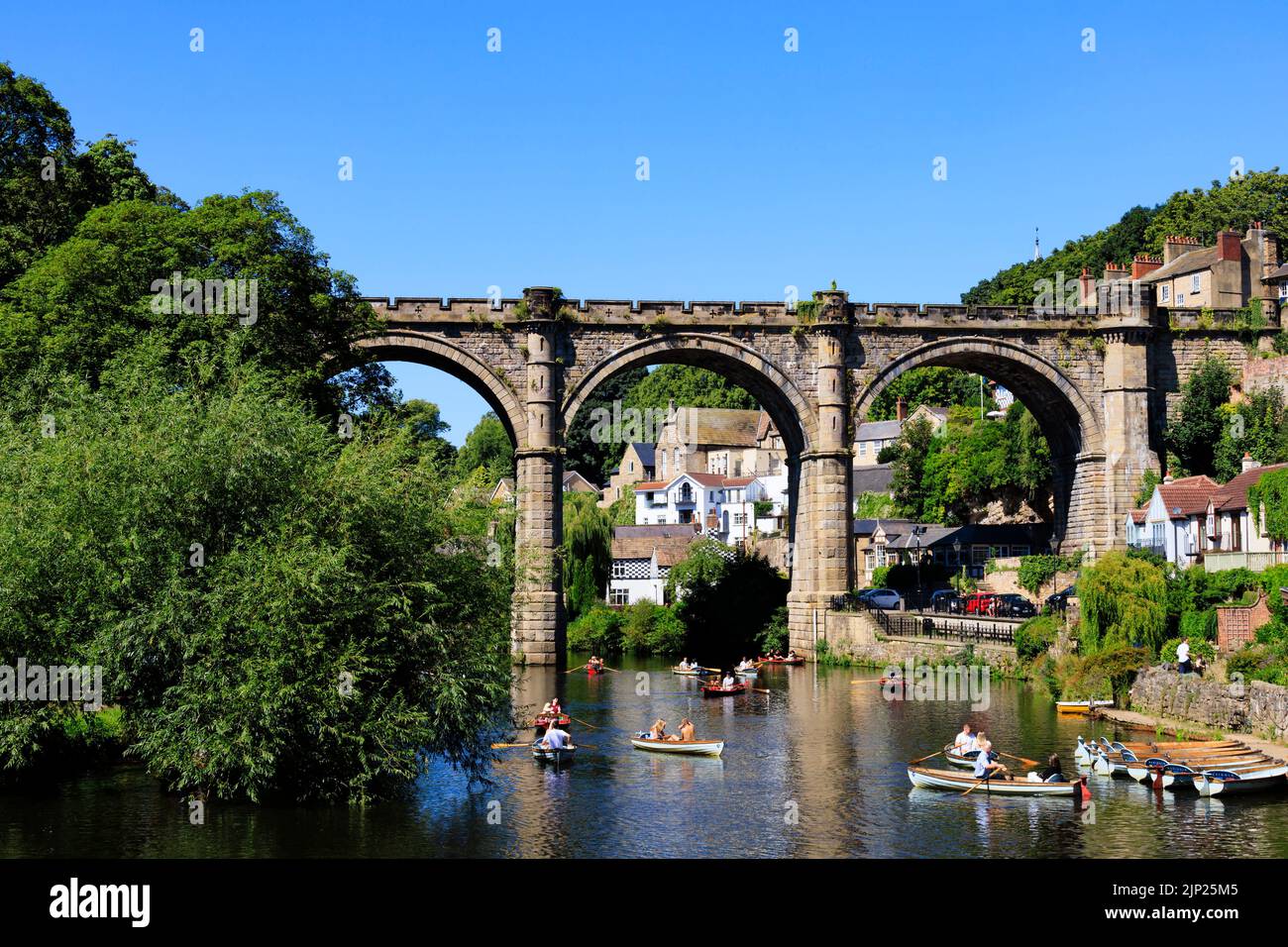 Le viaduc ferroviaire au-dessus de la rivière Nidd, Knaresborough, North Yorkshire, Angleterre. Chaude journée d'été avec des gens sur des bateaux dans la rivière. Banque D'Images