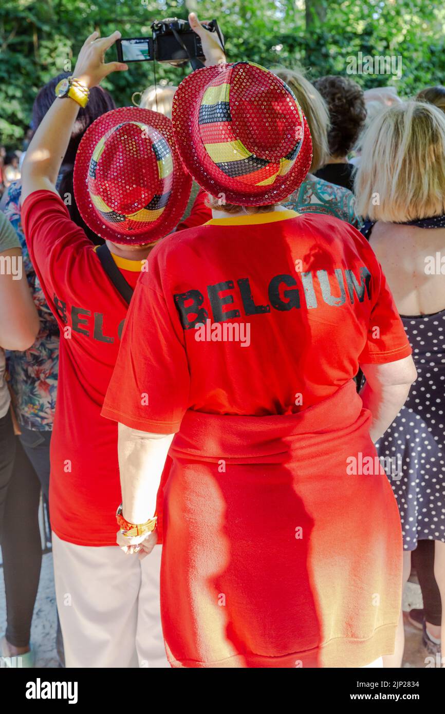 Deux dames vêtues aux couleurs nationales de la Belgique ont assisté au passage du roi dans le Parc de Bruxelles Banque D'Images