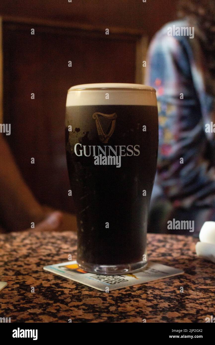 Une photo verticale d'un verre de Guinness sec sur une table en marbre au Stags Head Pub, Irlande Banque D'Images