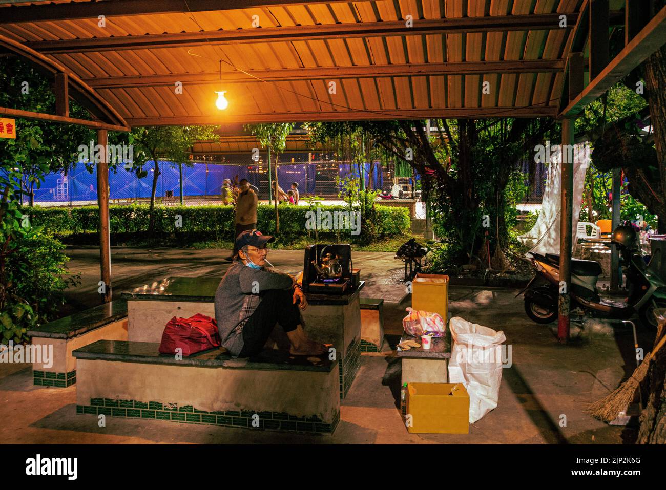 Vue d'une personne qui fume sous l'abri la nuit à Taipei, Taïwan Banque D'Images