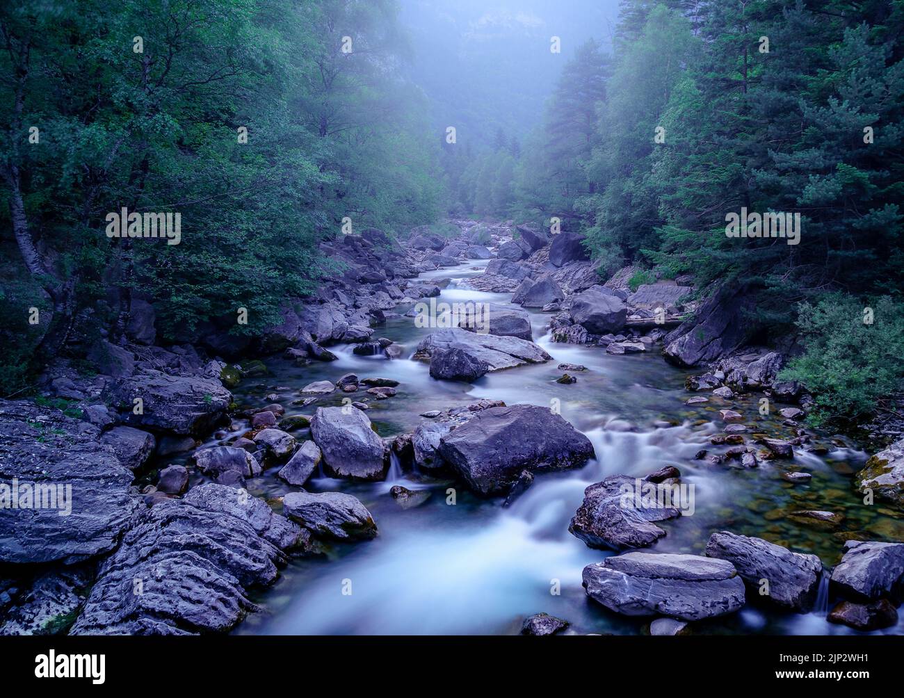 Paysage bleu avec rivière et lumière froide d'hiver. Nuit et atmosphère mystique, magique et hantant. Ordesa Pyrénées. Banque D'Images
