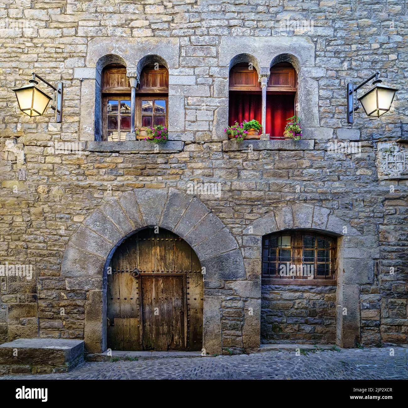 Rue d'une vieille ville médiévale avec des maisons en pierre et des planchers pavés, des lampes de rue et une atmosphère d'époque révolue. Espagne, Ainsa, Banque D'Images