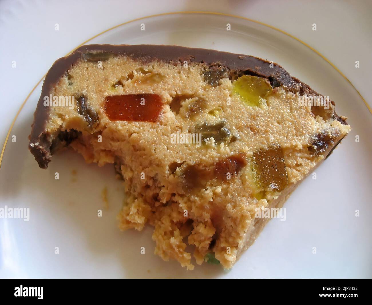 Rouler le gâteau avec des bonbons en gelée recouverts de chocolat sur la plaque blanche Banque D'Images