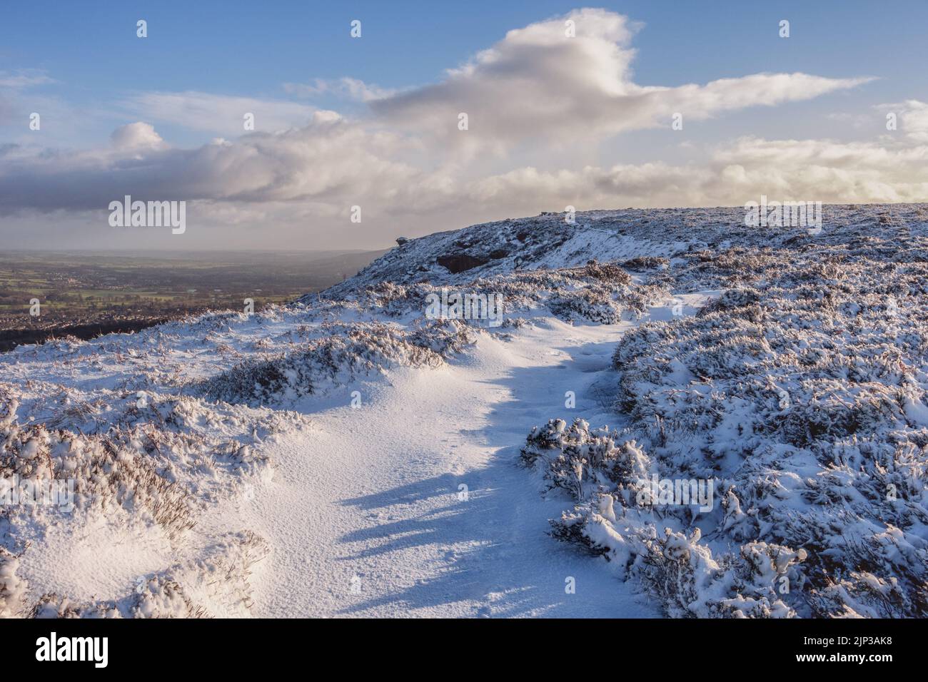 Paysages du Royaume-Uni : neige dans le Yorkshire à l'attraction touristique emblématique d'Ilkley Moor avec la pierre de Pancake et un sentier enneigé, West Yorkshire, Angleterre Banque D'Images