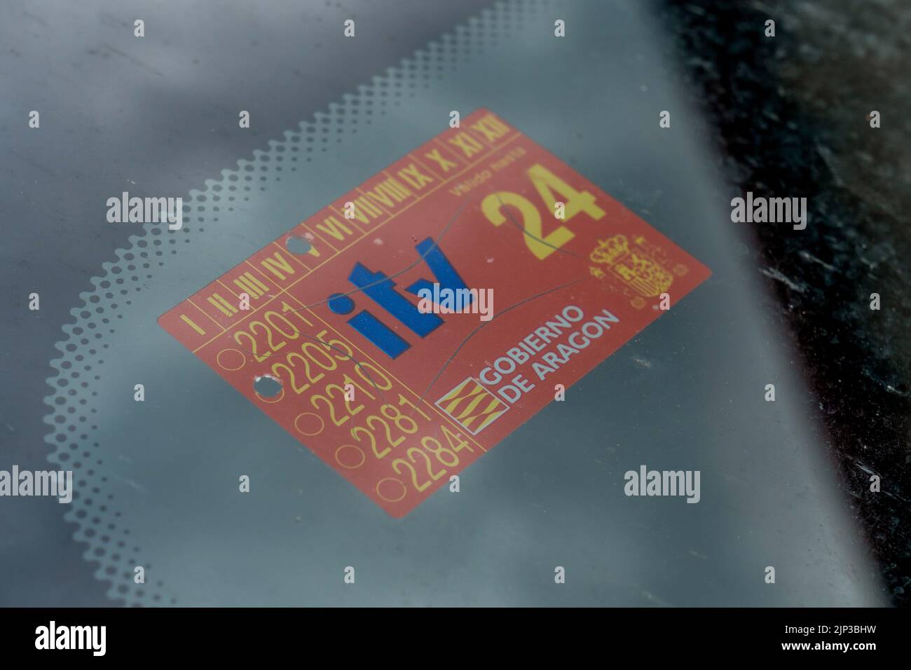 Gros plan d'un autocollant d'inspection technique du véhicule de couleur rouge sur une vitre de voiture Banque D'Images