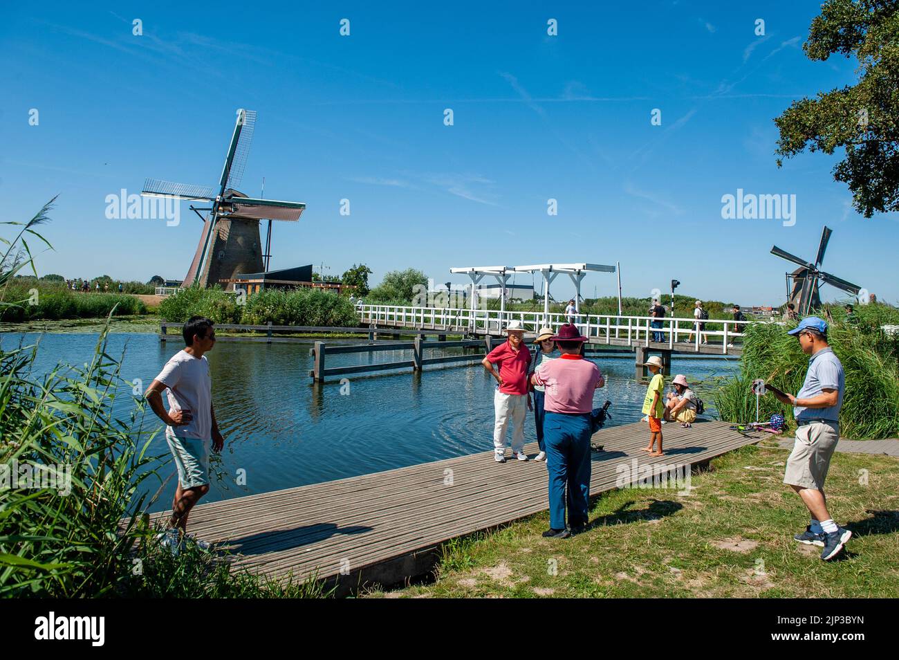 Kinderdijk, pays-Bas. 13th août 2022. Les visiteurs du monde entier prennent des photos avec les moulins à vent derrière eux. Dans la belle région riche en eau près de Dordrecht, vous trouverez les moulins à vent de Kinderdijk. Construits vers 1740, ces 19 magnifiques moulins à vent font partie d'un plus grand système de gestion de l'eau pour éviter les inondations. Aujourd'hui, ils symbolisent la gestion de l'eau aux pays-Bas et, en 1997, ils ont été déclarés site du patrimoine mondial de l'UNESCO. Chaque année, des milliers de touristes du monde entier visitent ce lieu emblématique. Crédit : SOPA Images Limited/Alamy Live News Banque D'Images