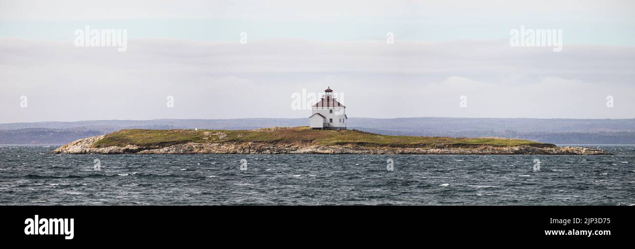 Un phare sur une île avec de grandes vagues à la mer Banque D'Images