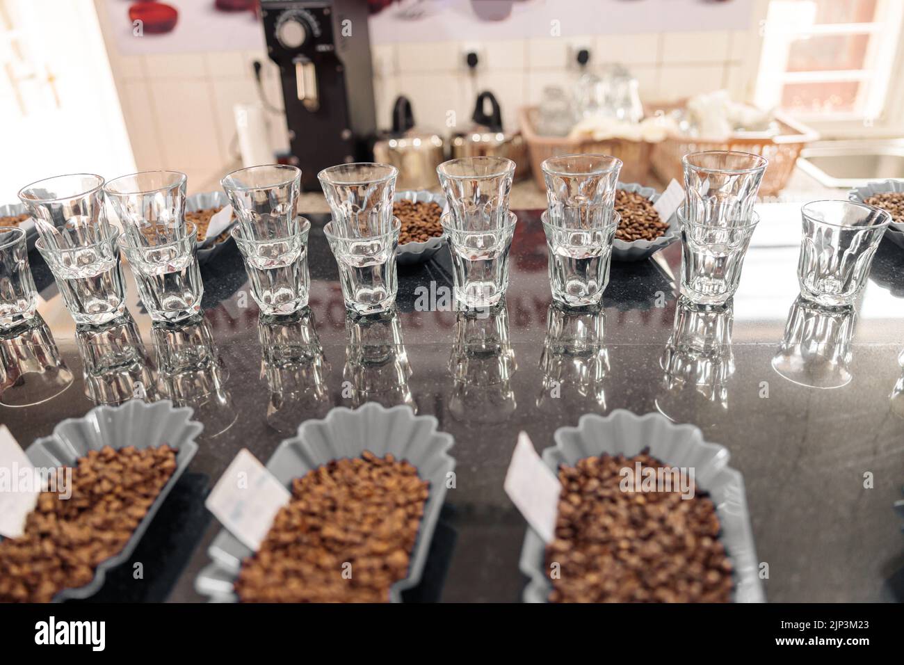 Verres à eau et bols avec grains de café dans une rangée sur la table Banque D'Images