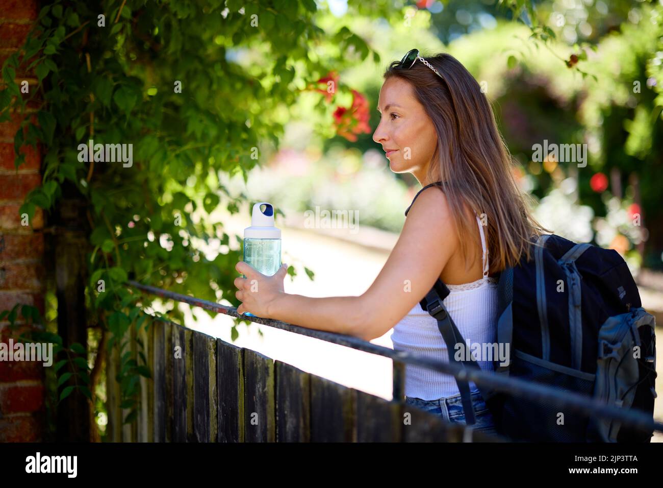 Femme se détendant à l'extérieur avec une bouteille d'eau Banque D'Images