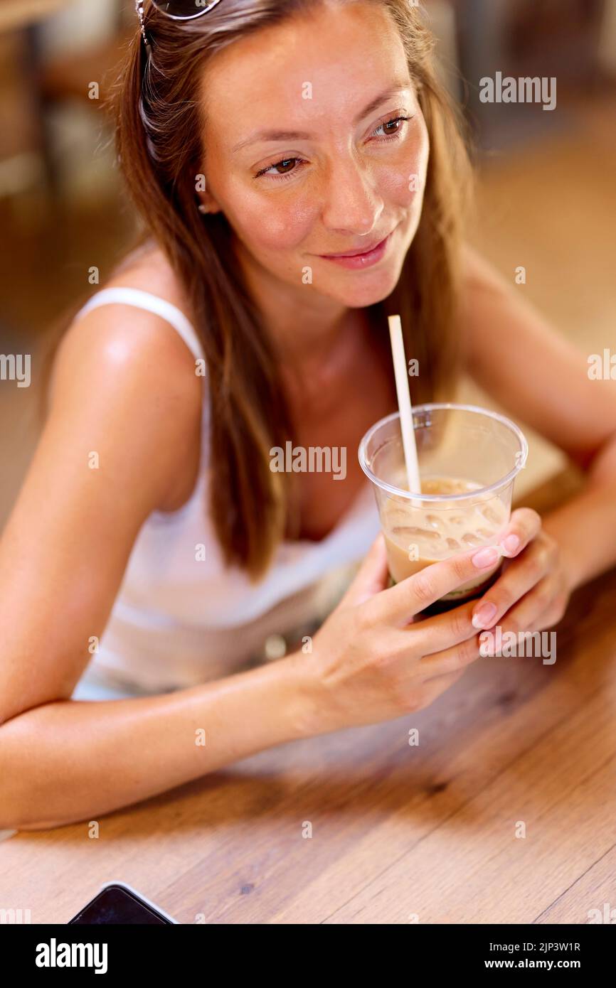 Femme détendue boire du café glacé Banque D'Images