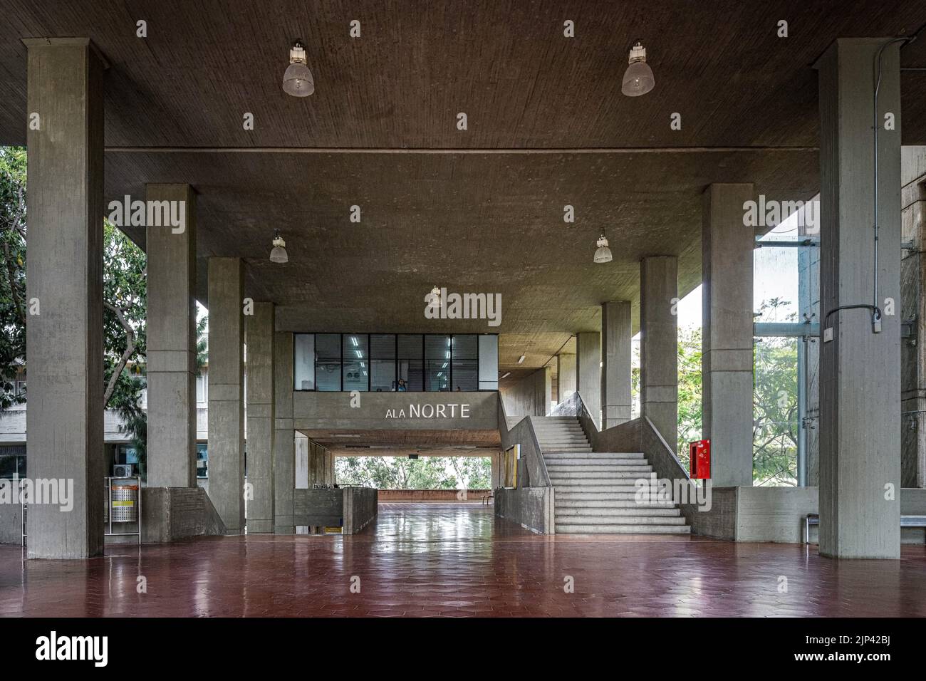 mezzanine, grande pièce vide, architecture brutaliste, avec des plafonniers, des escaliers et un sol carrelé rouge. Banque D'Images