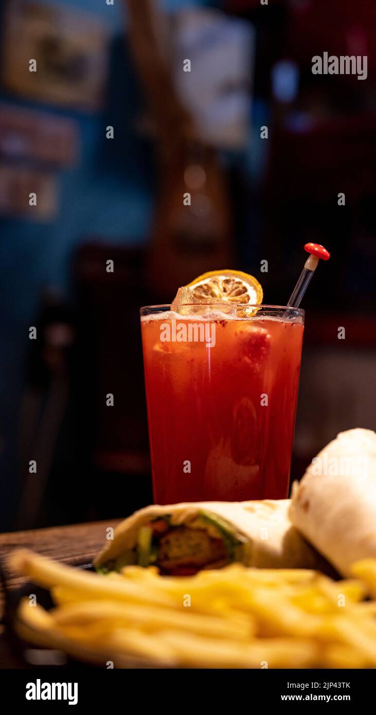 Vue verticale d'une limonade aux fraises et d'un buritto avec frites sur un fond flou Banque D'Images
