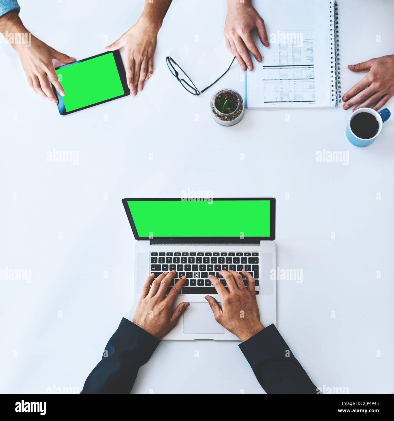 Hommes d'affaires sur tablette et ordinateur portable avec écran vert montrant le marketing, la publicité ou le copyspace d'en haut. Saisie par le haut des mains, à l'aide de la technologie sans fil Banque D'Images