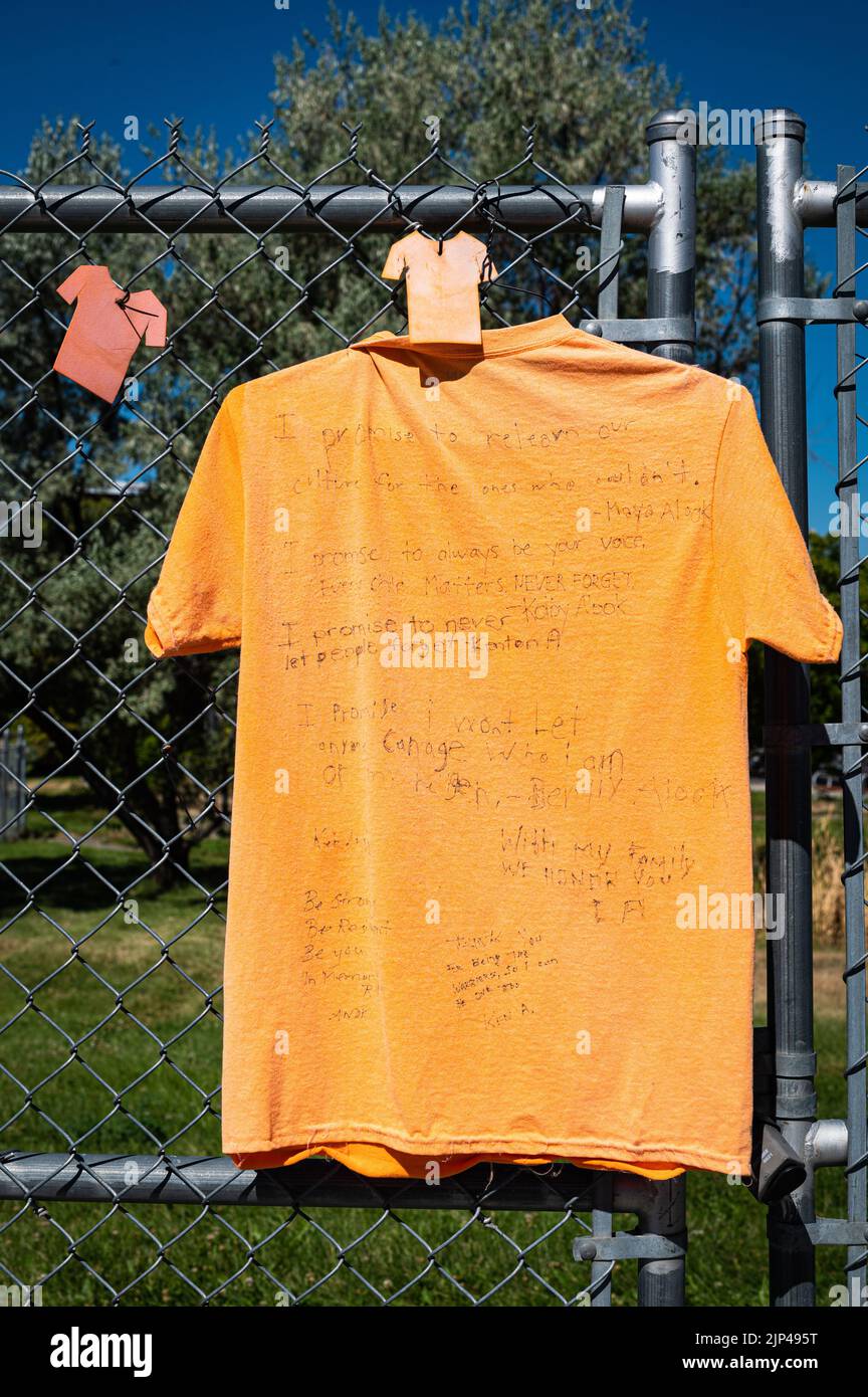 Un t-shirt avec des messages manuscrits est accroché à une clôture de la Kamloops Residential School. Des restes non marqués ont été trouvés sur le site, Banque D'Images