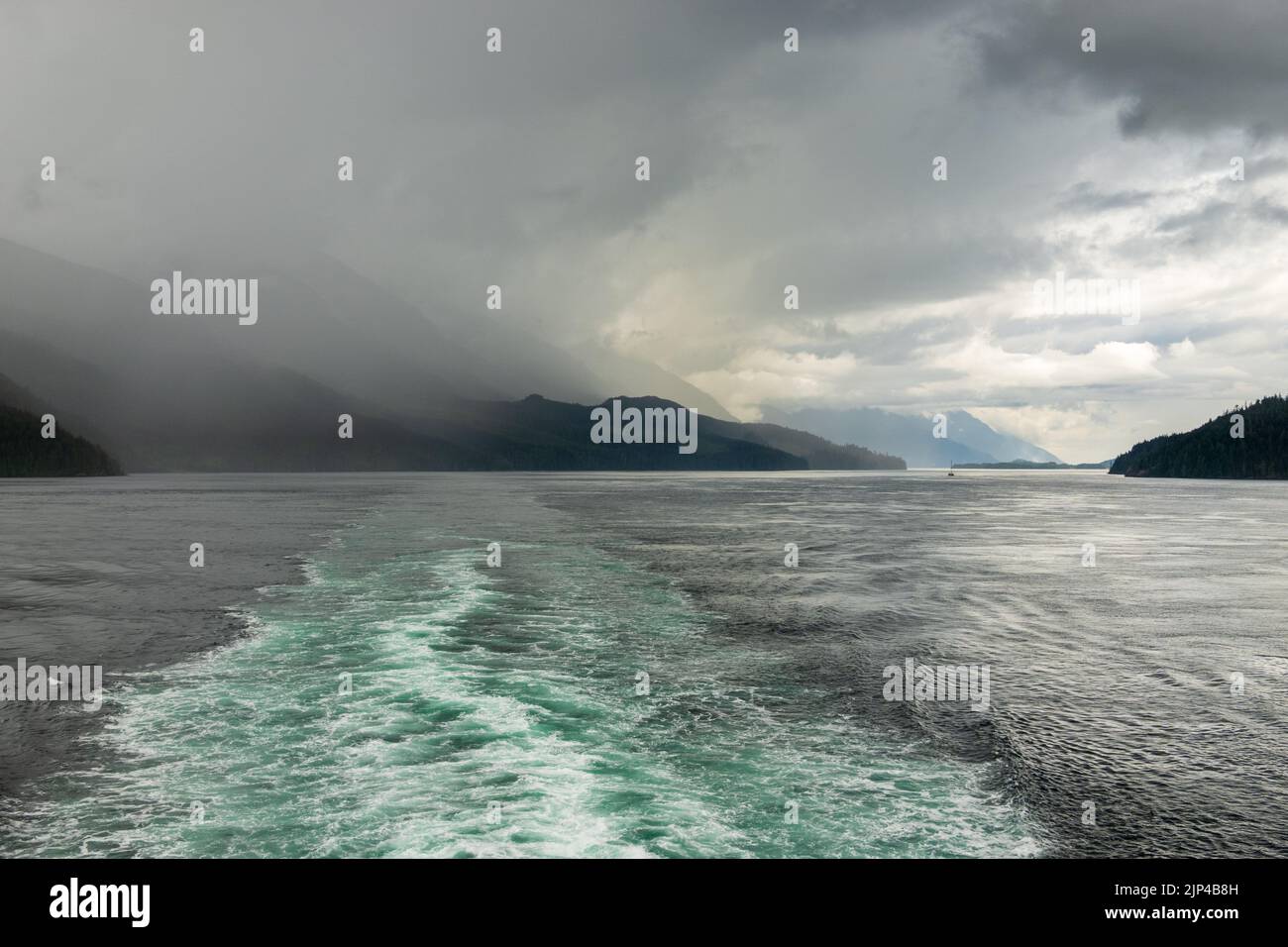 le réveil d'un bateau de croisière ramène le passage intérieur lors d'une visite de l'Alaska à la tempête de pluie Banque D'Images