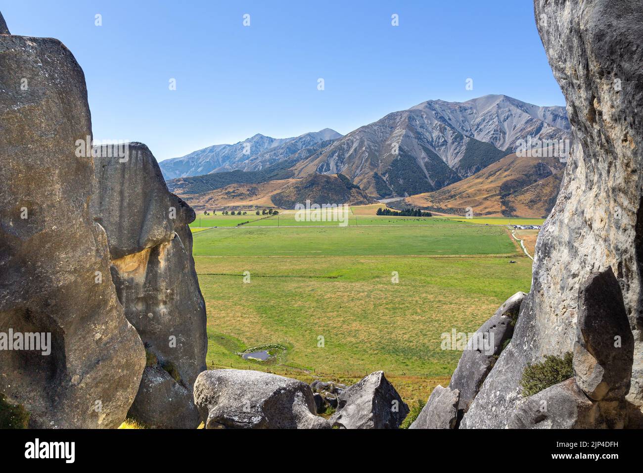 Vue sur les Alpes du Sud parmi les formations rocheuses naturelles de la zone protégée de Castle Hill, près de Christchurch, Nouvelle-Zélande. Banque D'Images