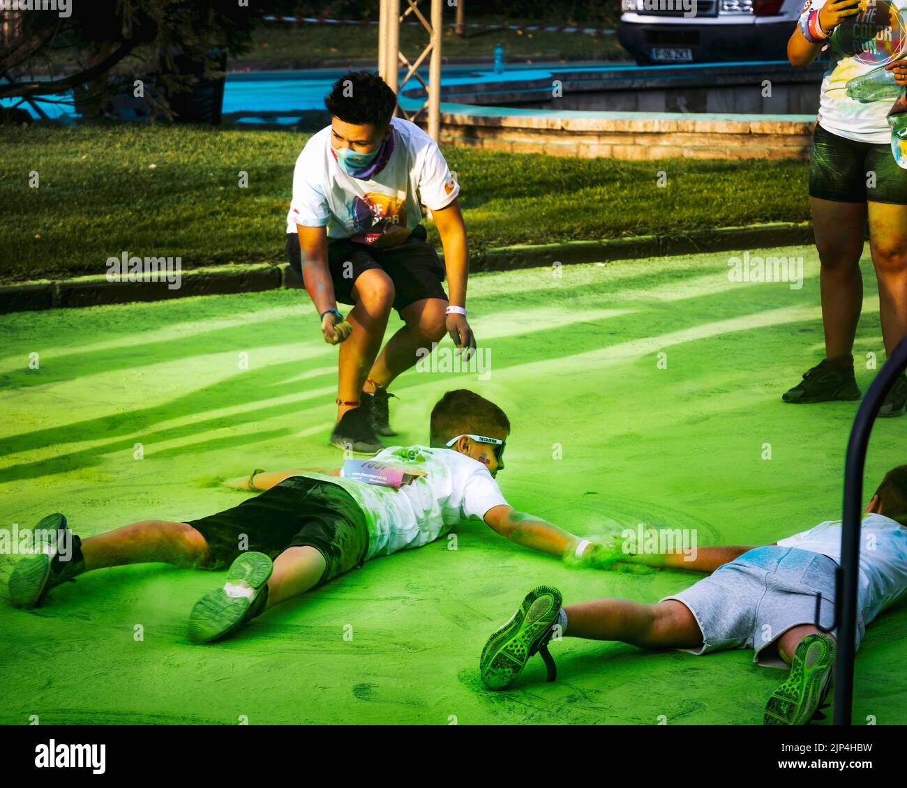 Le Festival Color Run de Bucarest, en Roumanie, avec des enfants jouant avec le pigment vert couvrant le sol Banque D'Images