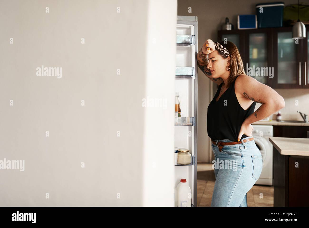 Plus de taille, chubby et femme affamée à la recherche d'un réfrigérateur, penser à la nourriture ou à la recherche de repas pendant un régime. Femme stressée, inquiète et frustrée Banque D'Images