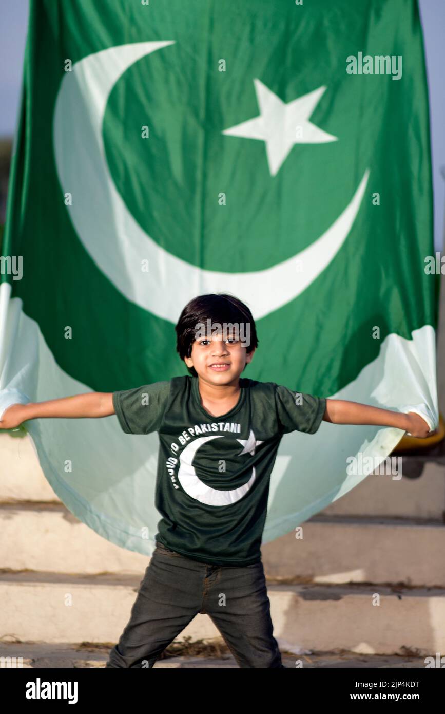 Petit garçon patriote debout et appréciant avec le drapeau du Pakistan. Concept du jour de l'indépendance du Pakistan. Banque D'Images