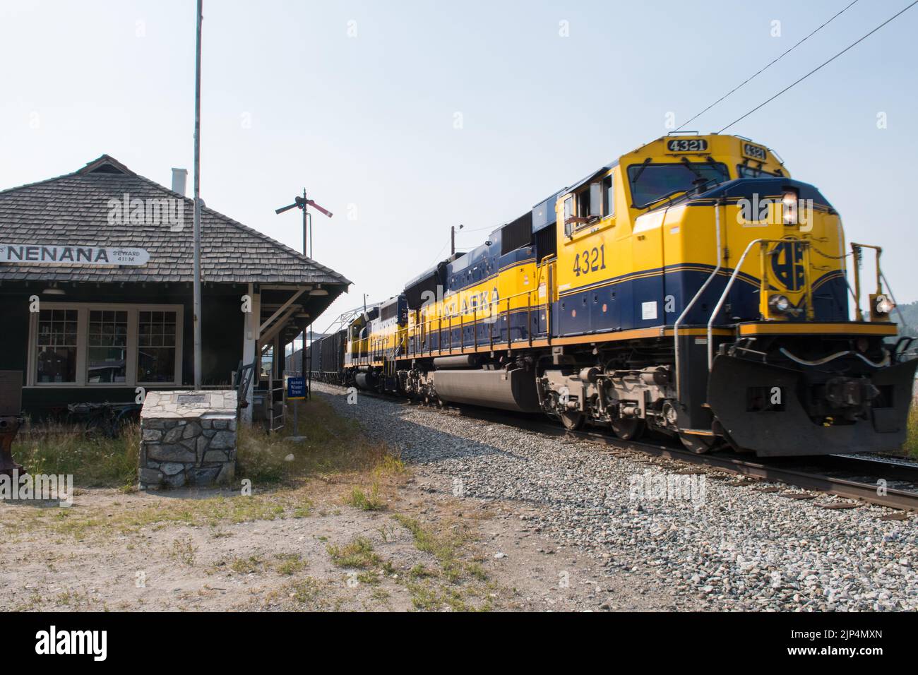 Un mécanicien de train déferle la fenêtre tandis que son moteur de train de chemin de fer de l'Alaska passe la gare de Nenana, Alaska, États-Unis Banque D'Images