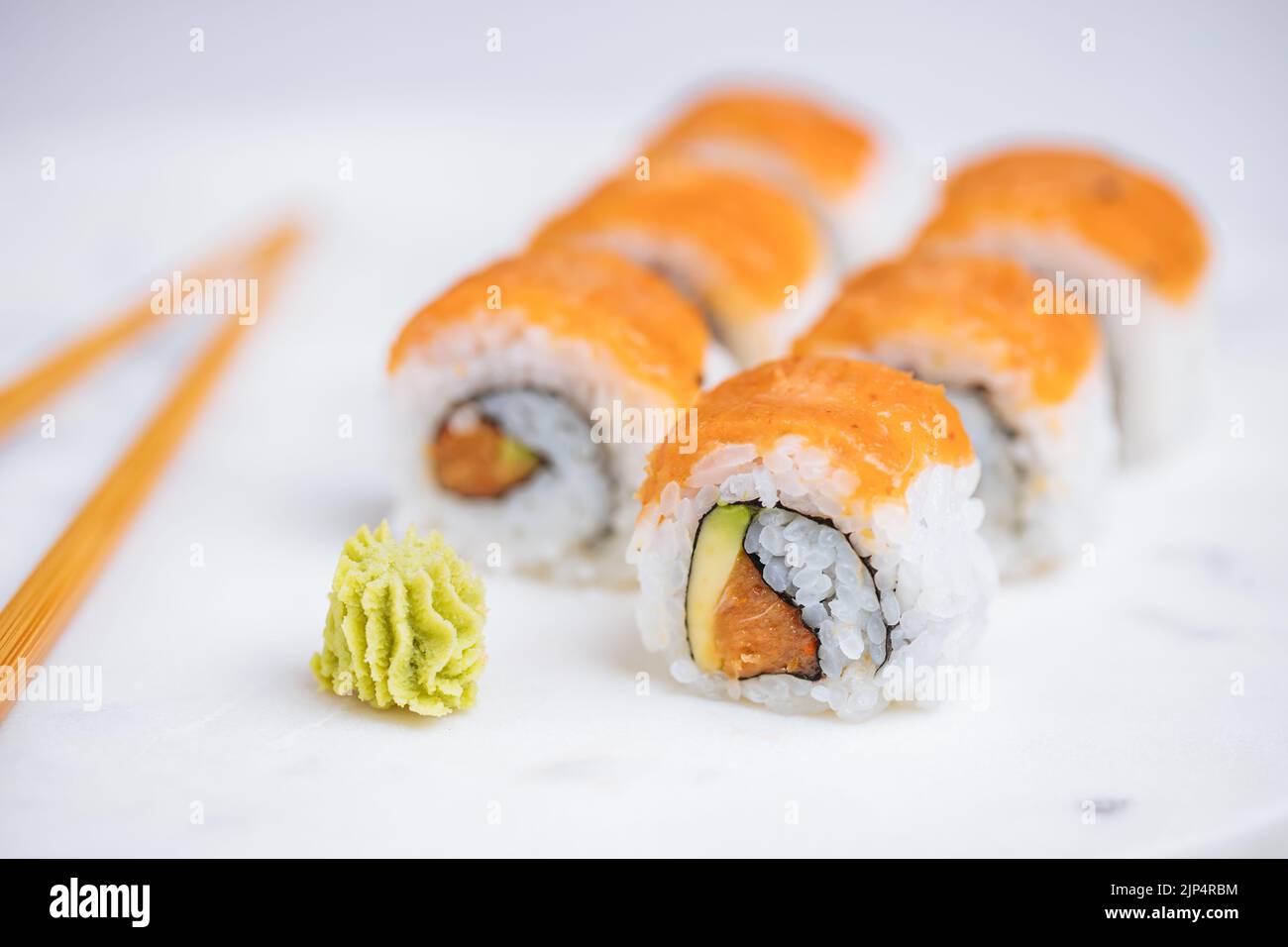 Petits pains à sushis sur plateau, fond lumineux. Servi avec du wasabi et du gingembre. Assortiment de sushis japonais. Cuisine traditionnelle. Banque D'Images