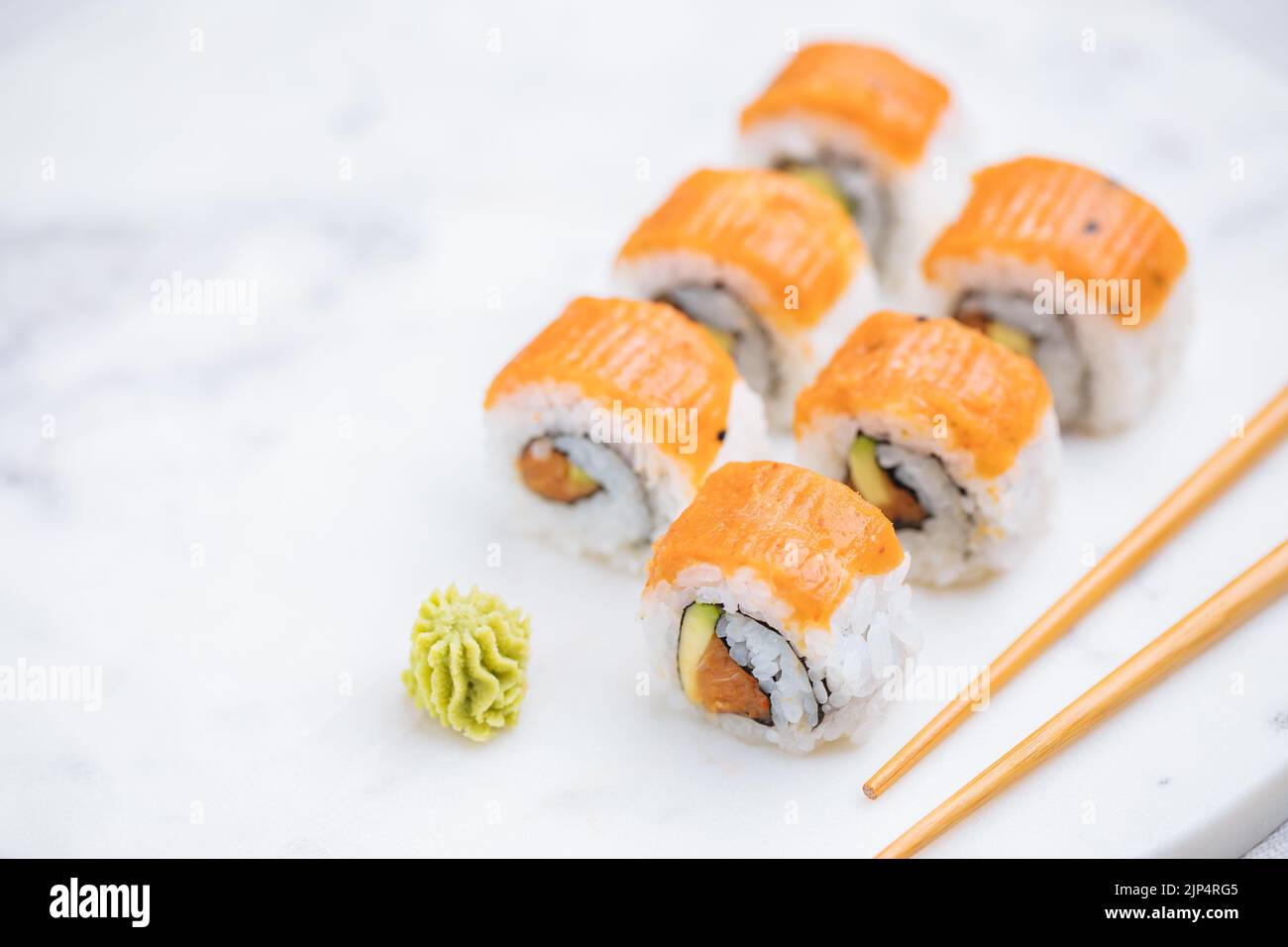 Petits pains à sushis sur plateau, fond lumineux. Servi avec du wasabi et du gingembre. Assortiment de sushis japonais. Cuisine traditionnelle. Banque D'Images