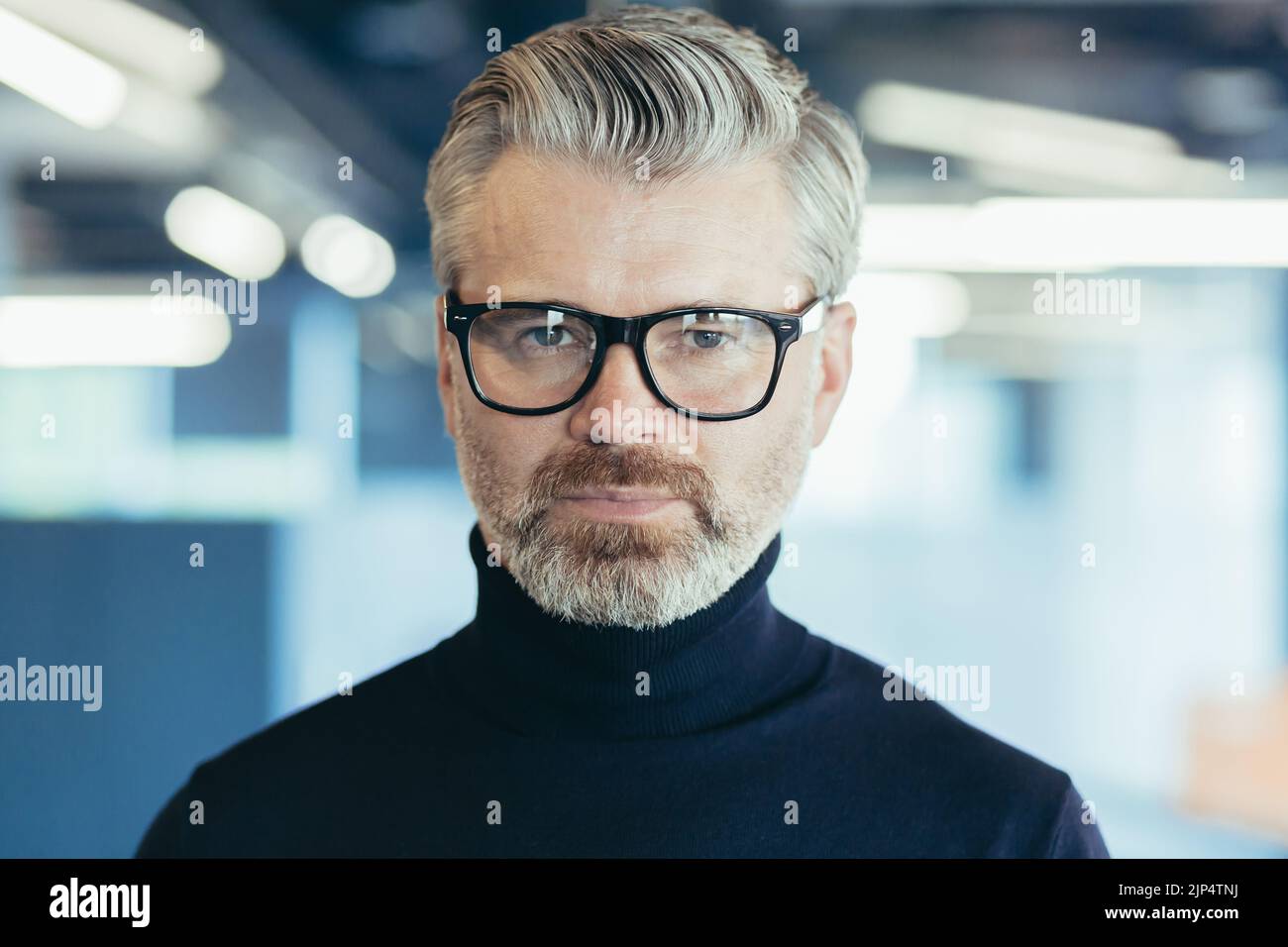 Gros plan portrait photo d'un homme d'affaires sérieux et mature, investisseur en lunettes regardant attentivement l'appareil photo, homme au travail à l'intérieur du bureau Banque D'Images