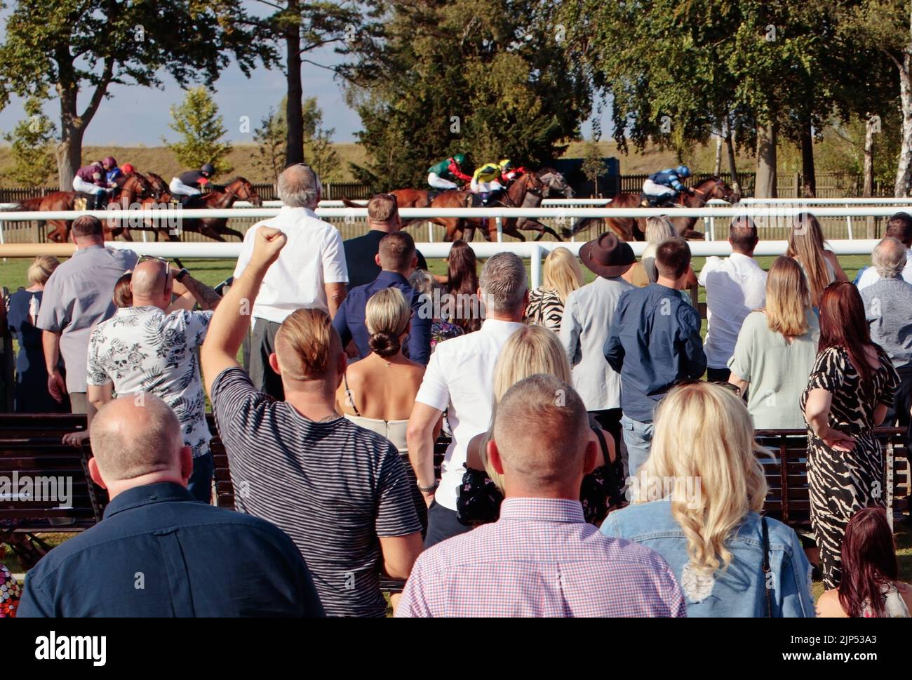 Jubilant homme pointant l'air, tandis que les acclamations de spectateurs et de punteurs heureux aux courses de Newmarket, Newmarket, Suffolk, Angleterre, Royaume-Uni Banque D'Images