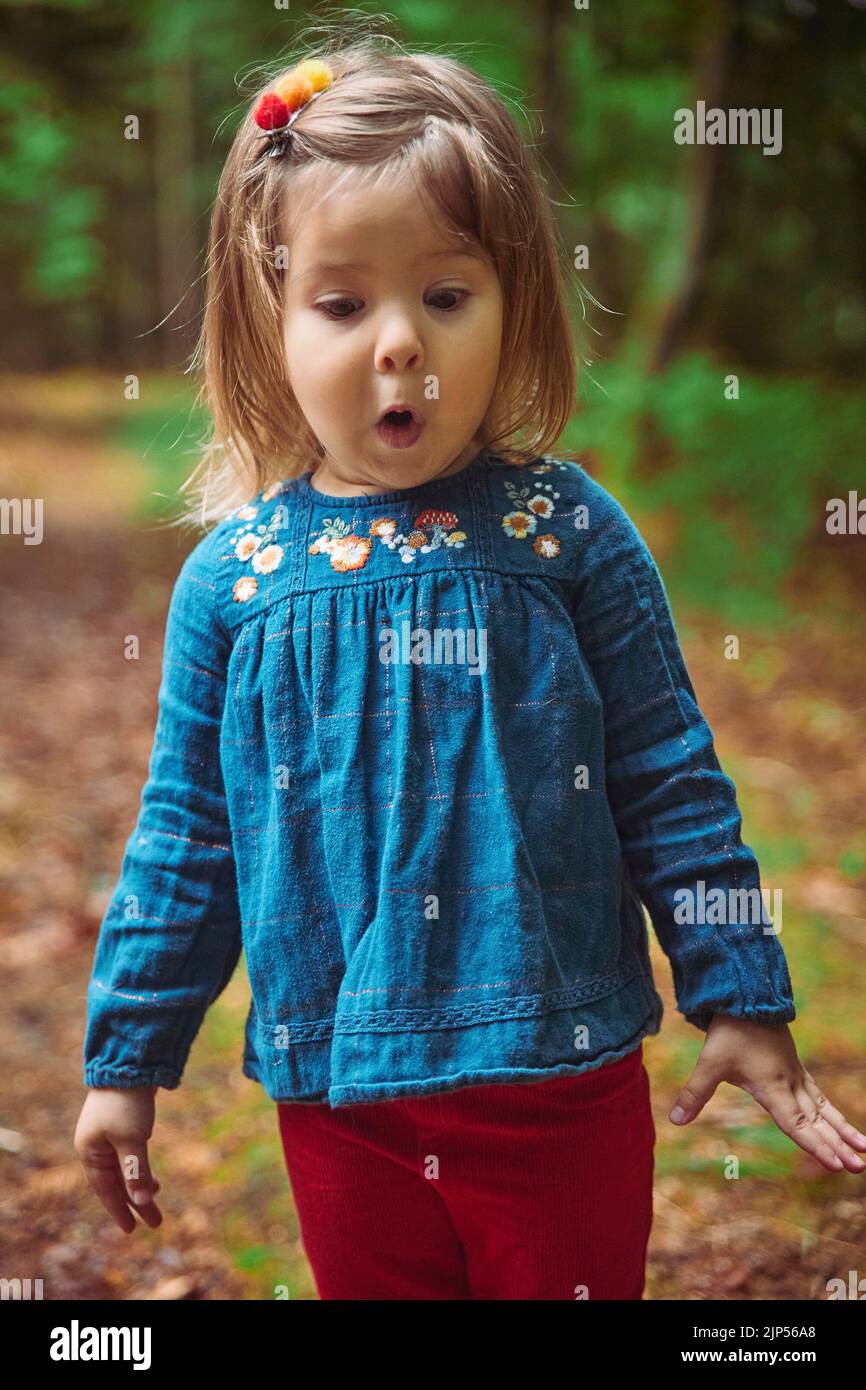 magnifique bébé dans une chemise brodée jouer dans la forêt Banque D'Images