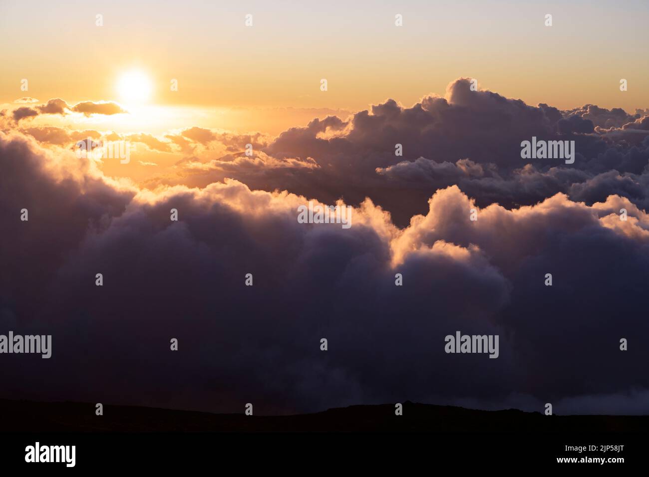 Coucher de soleil au-dessus des nuages depuis le sommet du volcan Haleakala Banque D'Images
