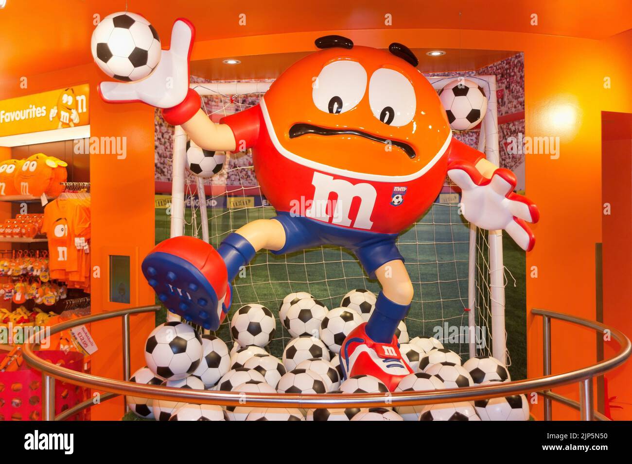 Une statue d'orange dans une pile de ballons de football au MM's World à Londres Banque D'Images