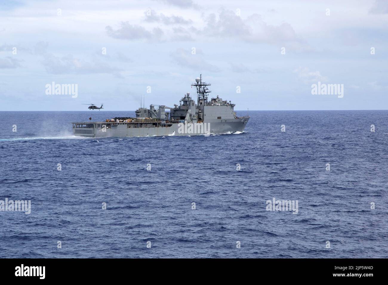 220815-N-XN177-1203 MER DES PHILIPPINES (AOÛT 15, 2022) – un hélicoptère MH-60s Sea Hawk affecté à l'Escadron de combat de la mer (HSC) 23 ramasse les fournitures du navire d'atterrissage sur quai amphibie USS Rushmore (LSD 47) lors d'un réapprovisionnement vertical, le 15 août 2022. Rushmore fait partie du Tripoli Amphiobie Ready Group (ARG). L'ARG de Tripoli, en collaboration avec le Marine Expeditionary Group de 31st, opère dans la zone d'opérations de la flotte américaine de 7th afin d'améliorer l'interopérabilité avec les alliés et les partenaires et de servir de force d'intervention prête pour défendre la paix et maintenir la stabilité dans la région Indo-Pacifique. (É.-U. Banque D'Images