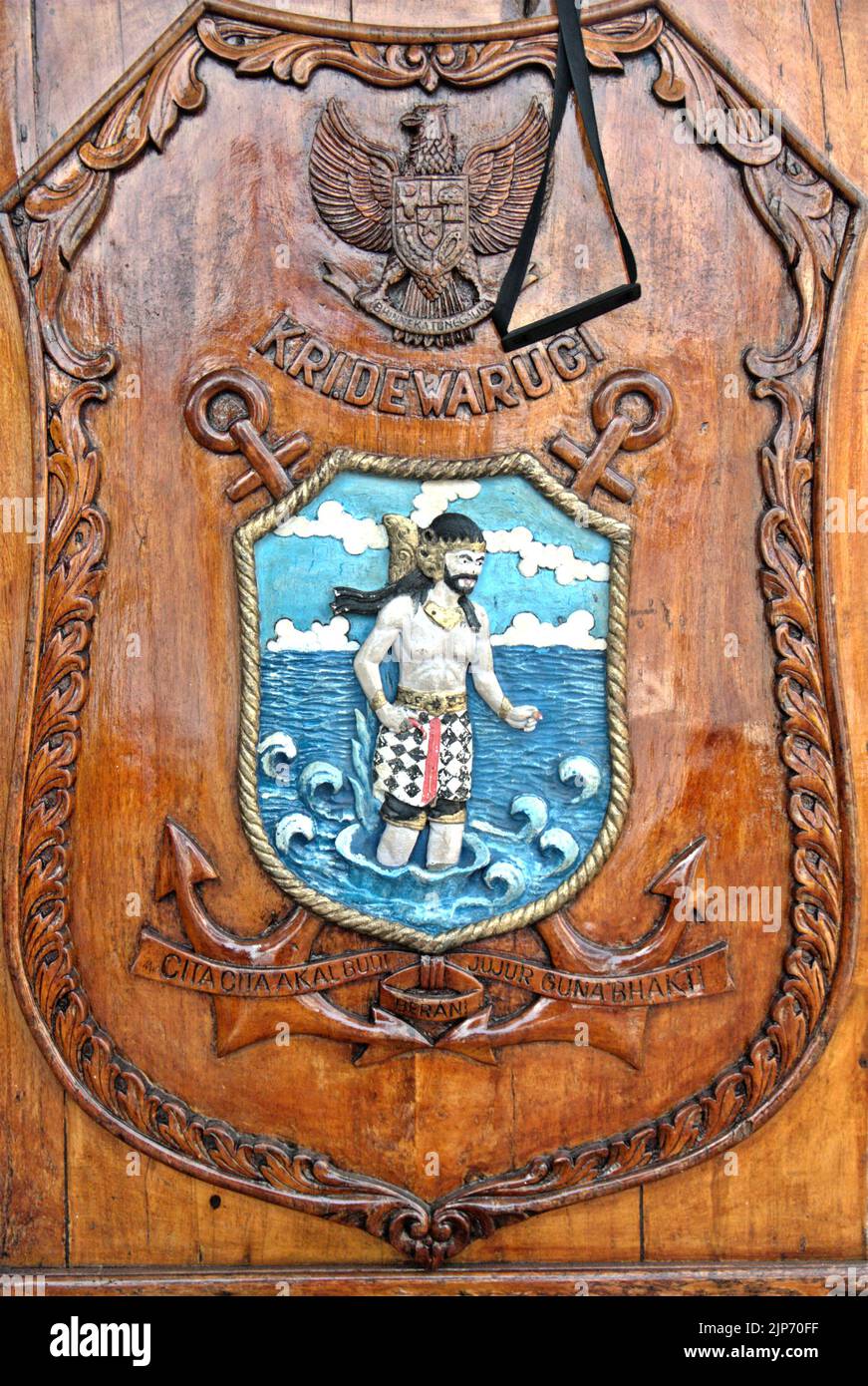 Une image de Bhima, l'un des frères Pandava, est vue sur une bannière debout placée sur la plate-forme du port, comme KRI Dewaruci (Dewa Ruci), un grand navire indonésien, comme la goélette de type barquentine est ouverte aux visiteurs publics au port de Kolinlamil (port de la Marine) à Tanjung Priok, dans le nord de Jakarta, Indonésie. Bhima est un symbole du grand navire de la marine indonésienne. Banque D'Images