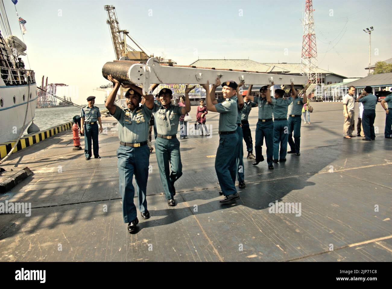 Des officiers de la marine indonésienne portant une échelle métallique se promenant sur la plate-forme du port, sur le côté de KRI Dewaruci (Dewa Ruci), un grand navire indonésien, lorsque la goélette de type barquentine est ouverte aux visiteurs publics au port de Kolinlamil (port de la marine) à Tanjung Priok, dans le nord de Jakarta, en Indonésie. Banque D'Images