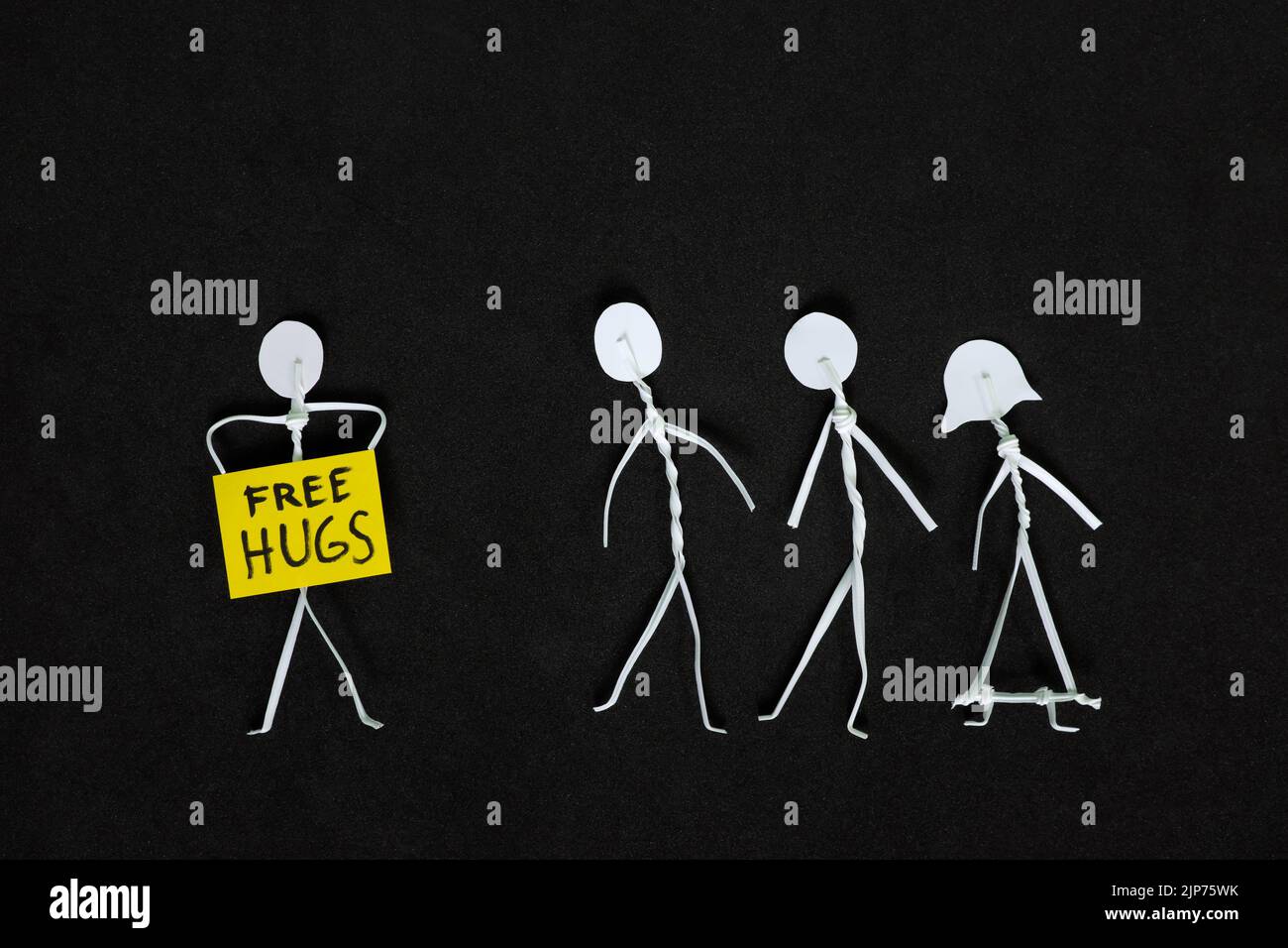 Libre de câlins et de diffuser la positivité et la bonté aux étrangers concept. Affiche représentant un homme en forme de bâton tenant une étiquette d'affichage indiquant que les tasses sont libres. Banque D'Images