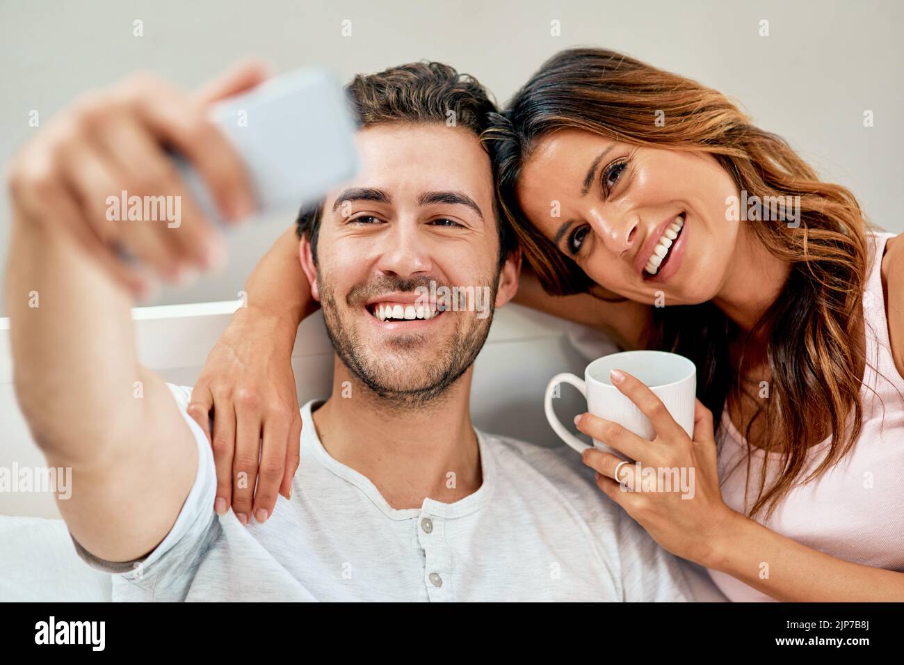 Il est temps de prendre des selfies pour le week-end. Un jeune couple heureux prend un selfie à la maison. Banque D'Images